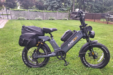Grey Aniioki AQ177 48V electric bike with saddlebags parked on a residential green lawn, illustrating ebike Class 1 2 3 4 differences for long distance commuting.