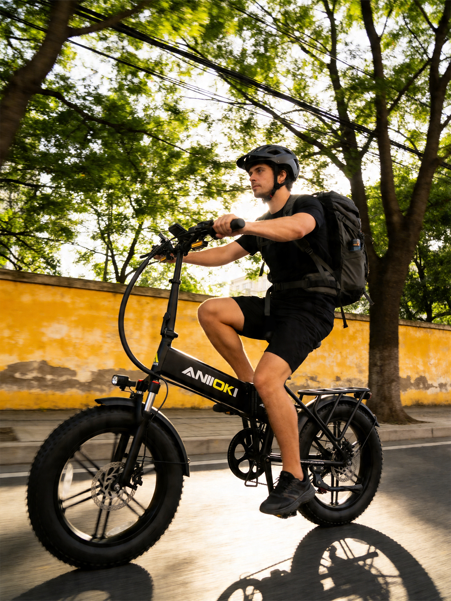 Person riding an electric bike with 'ANBIKE' branding on a sunny day.